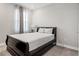 Cozy bedroom featuring a dark bed frame, plush white bedding, and soft lighting at 4784 San Martino Dr, Wesley Chapel, FL 33543