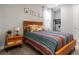 Bedroom with colorful bedding, a rustic wooden headboard, and a nightstand with a lamp at 4784 San Martino Dr, Wesley Chapel, FL 33543