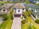 Inviting two-story home boasting a paver driveway, 2-car garage, and lush tropical landscaping at 4784 San Martino Dr, Wesley Chapel, FL 33543