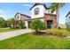 Well-maintained home showcasing a two-car garage, landscaped front yard, and stone accents at 4784 San Martino Dr, Wesley Chapel, FL 33543