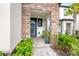 Cozy front porch adorned with stone columns, a vibrant wreath, and lush plantings at 4784 San Martino Dr, Wesley Chapel, FL 33543