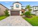 Charming two-story house featuring a paved driveway, two-car garage, and well-manicured lawn at 4784 San Martino Dr, Wesley Chapel, FL 33543