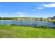 Scenic lake view with lush green lawn and attractive single Gathering homes against a beautiful blue sky at 4784 San Martino Dr, Wesley Chapel, FL 33543