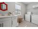 This laundry room offers a utility sink, a decorative mirror and modern washer and dryer at 4784 San Martino Dr, Wesley Chapel, FL 33543