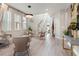 Bright, open living room with modern chandelier, light wood floors and large windows, creating an inviting space at 4784 San Martino Dr, Wesley Chapel, FL 33543