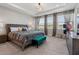 Main bedroom featuring tray ceiling, windows, patterned drapes, and carpet at 4784 San Martino Dr, Wesley Chapel, FL 33543