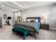 This bright main bedroom features a tray ceiling, and an exercise bike adjacent to the sleeping area at 4784 San Martino Dr, Wesley Chapel, FL 33543