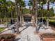 Community pavilion with picnic tables and umbrellas, surrounded by lush landscaping and mature trees at 4784 San Martino Dr, Wesley Chapel, FL 33543