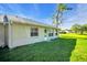 Back exterior view of home with a manicured lawn and access to the backyard at 4819 Boonesboro Ct, New Port Richey, FL 34655