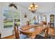 Bright dining room with large windows and a charming chandelier, perfect for Gathering meals at 4819 Boonesboro Ct, New Port Richey, FL 34655