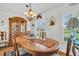 This dining room features hardwood floors, a chandelier, and a large window at 4819 Boonesboro Ct, New Port Richey, FL 34655