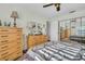 A well-lit main bedroom features carpeted floors, a ceiling fan, a large window, and a full dresser set at 4819 Boonesboro Ct, New Port Richey, FL 34655