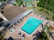 Aerial view of a community pool with ample lounge chairs, palm trees, and shade at 4819 Boonesboro Ct, New Port Richey, FL 34655