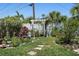 Lush backyard garden with stepping stones, plants, and a decorative white trellis at 5053 43Rd S St, St Petersburg, FL 33711