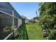 Spacious backyard with green lawn, landscaping, and a screened porch with an exterior view at 5053 43Rd S St, St Petersburg, FL 33711
