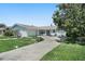 Attractive single-story home featuring a circular driveway, well-kept lawn, and appealing landscaping at 5053 43Rd S St, St Petersburg, FL 33711