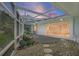 Covered patio with stone ground covering, stepping stones, and screen walls with a beautiful sunset in the background at 5053 43Rd S St, St Petersburg, FL 33711