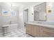 Bright bathroom featuring a standalone tub, checkered floors, and a marble vanity with a large mirror at 5142 W San Jose St, Tampa, FL 33629