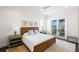 Bedroom with neutral tones, a queen bed, and doors leading to an outdoor balcony at 5142 W San Jose St, Tampa, FL 33629