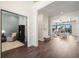 Hallway with hardwood floors leading to a sunlit living area and adjacent room with wainscoting at 5142 W San Jose St, Tampa, FL 33629