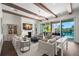 Bright living room featuring exposed beams, waterfront view through sliding glass doors, and comfortable seating at 5142 W San Jose St, Tampa, FL 33629