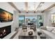 Cozy living room featuring a fireplace, beamed ceilings, and a view of the outdoor dining area at 5142 W San Jose St, Tampa, FL 33629