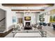 Elegant living room with fireplace, beamed ceilings, neutral furnishings, and access to the outdoor patio at 5142 W San Jose St, Tampa, FL 33629