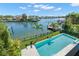 Aerial view of a blue inground pool, surrounded by palms, next to the intercoastal waterway at 5142 W San Jose St, Tampa, FL 33629