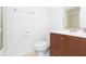 Bathroom featuring a wooden vanity, a mirror, and a toilet, combining style and functionality at 5421 Orange Blossom N Rd, Pinellas Park, FL 33782