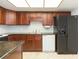 Functional kitchen with dark wood cabinets, granite countertops, and black refrigerator at 5421 Orange Blossom N Rd, Pinellas Park, FL 33782