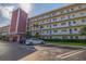 Exterior view of condo building with parking spaces, lush landscaping, and well-maintained grounds at 5575 Gulf Blvd # 329, St Pete Beach, FL 33706