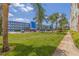 Condo building with lush lawn, palm trees, and parking area on a bright day at 5575 Gulf Blvd # 329, St Pete Beach, FL 33706