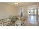 Dining area featuring a glass table, bamboo chairs, and hallway to updated kitchen at 5575 Gulf Blvd # 329, St Pete Beach, FL 33706
