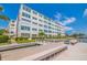 Community dock featuring bench seating and views of the condo building, waterway, and landscaping at 5575 Gulf Blvd # 329, St Pete Beach, FL 33706