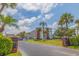 Low-angle shot of a condominium complex with tropical landscaping and mature palm trees at 5575 Gulf Blvd # 329, St Pete Beach, FL 33706