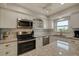 Bright kitchen featuring white cabinets, granite countertops, and stainless steel appliances at 5575 Gulf Blvd # 329, St Pete Beach, FL 33706