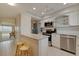 Updated kitchen features white cabinets, granite countertops and stainless steel appliances with a view to the living room at 5575 Gulf Blvd # 329, St Pete Beach, FL 33706