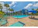 Community pool featuring ample seating, palm trees, and sunny skies in front of the condo building at 5575 Gulf Blvd # 329, St Pete Beach, FL 33706