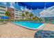 Community pool with plenty of lounge chairs in a tropical setting at 5575 Gulf Blvd # 329, St Pete Beach, FL 33706