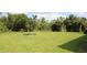 Spacious backyard featuring healthy green grass, mature trees, and natural surroundings, perfect for outdoor enjoyment at 6417 Blue Sail Ln, Apollo Beach, FL 33572