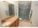Bathroom featuring granite countertops, a large mirror, and glass shower with blue stone tile at 6417 Blue Sail Ln, Apollo Beach, FL 33572