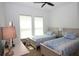 Bedroom with two twin beds featuring matching blue bedding and a ceiling fan at 6417 Blue Sail Ln, Apollo Beach, FL 33572
