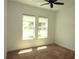 Bright bedroom features two windows, neutral carpet, and a ceiling fan at 6417 Blue Sail Ln, Apollo Beach, FL 33572