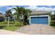 Inviting home with a blue garage door, complemented by meticulously maintained landscaping and lush green grass at 6417 Blue Sail Ln, Apollo Beach, FL 33572