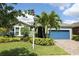Charming home showcasing mature palm trees, meticulously maintained landscaping, and a brick paver driveway at 6417 Blue Sail Ln, Apollo Beach, FL 33572