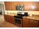 Well-lit kitchen with wooden cabinets, stainless steel appliances, and granite countertops at 6417 Blue Sail Ln, Apollo Beach, FL 33572