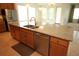 Kitchen island features a stainless steel dishwasher and sink, beautiful wood cabinetry, and granite countertops at 6417 Blue Sail Ln, Apollo Beach, FL 33572