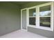 Covered patio features a smooth floor, windows, and a screen door for enjoying the outdoors at 6417 Blue Sail Ln, Apollo Beach, FL 33572