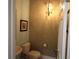 Cozy powder room with elegant wallpaper, hanging light fixture, and pedestal sink at 6417 Blue Sail Ln, Apollo Beach, FL 33572