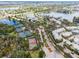An aerial view showcasing community amenities, tennis courts, a pool, and waterfront properties along the lakes at 716 Manns Harbor Dr, Apollo Beach, FL 33572